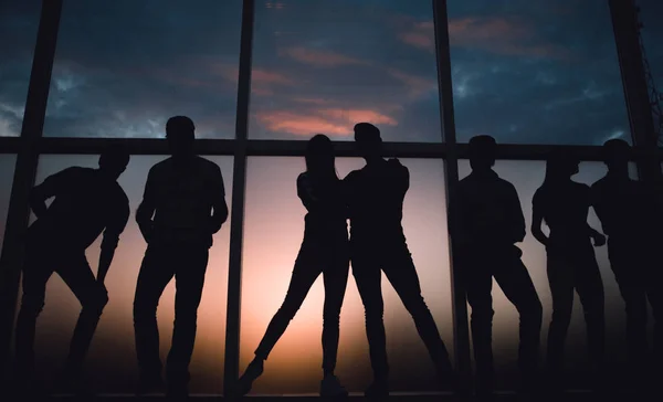 Grupo de jóvenes en el fondo de una gran ventana — Foto de Stock