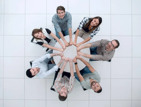 Usmívající se obchodní tým složen ruce tvoří kruh — Stock fotografie