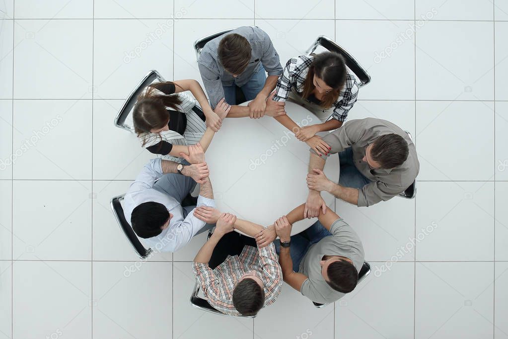 top view.The business team hold hands, forming a circle