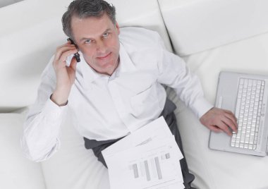 sandalyede oturan ve bir smartphon üzerinde konuşurken işadamı