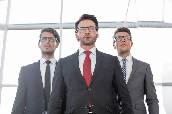 Da vicino.tre uomo d'affari fiducioso in piedi in ufficio — Foto Stock