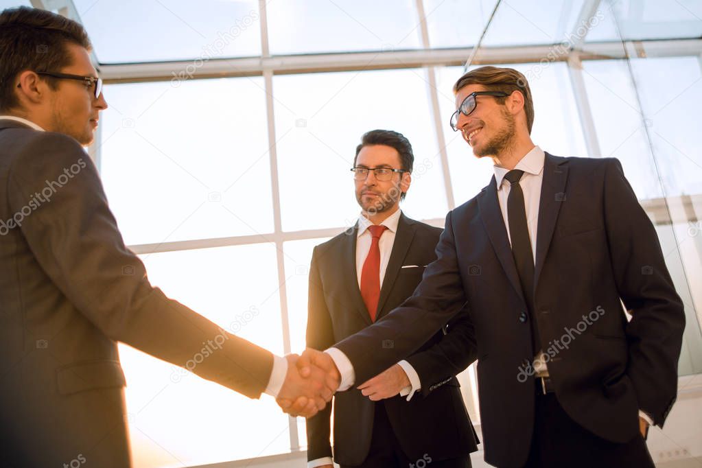 in the foreground is the handshake of business people