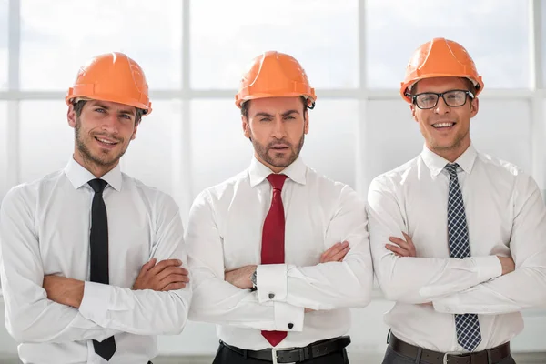 Close up.three confident business men in protective helmets — Stock Photo, Image