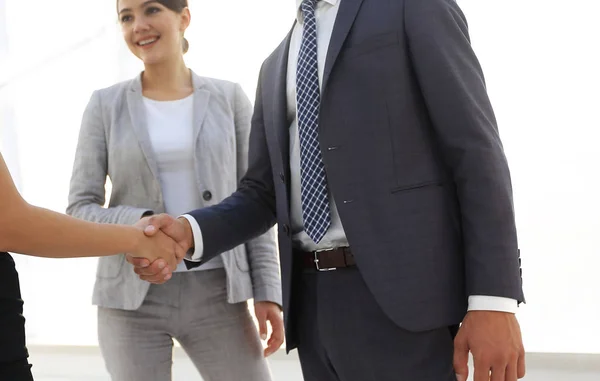 Zakenmensen schudden handen tegen de kamer met grote loo — Stockfoto