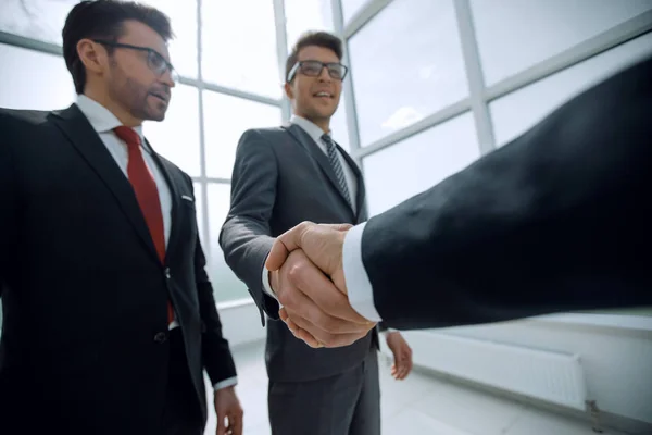 Bottom view.businessman raggiungere per una stretta di mano — Foto Stock