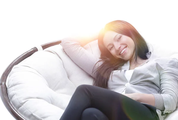 Jovem mulher sentada em uma poltrona grande macia confortável — Fotografia de Stock