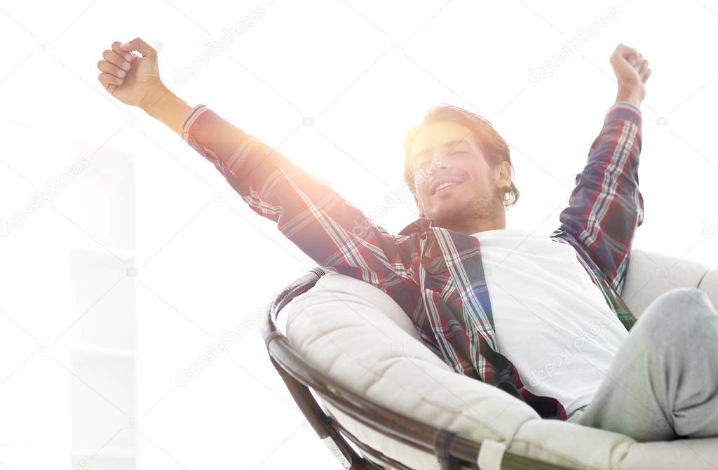 stylish guy stretching in a comfortable chair