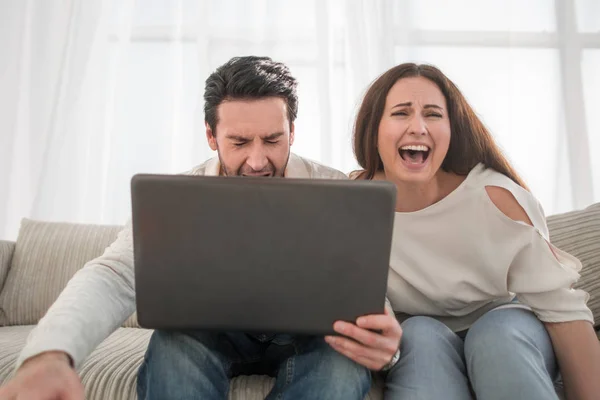 Gelukkige paar zittend op de Bank en met behulp van laptop thuis — Stockfoto