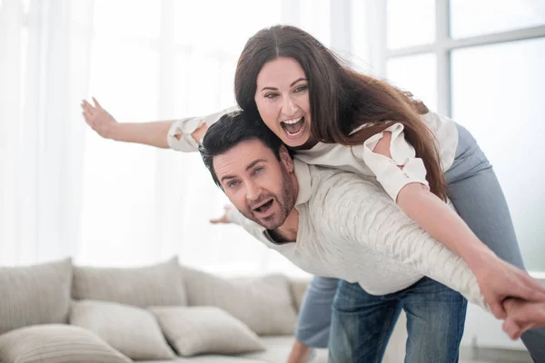 Pareja feliz descansando en una amplia sala de estar . — Foto de Stock