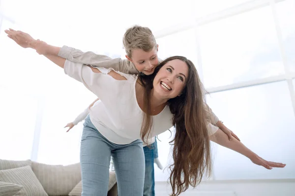 Mutter spielt mit ihrem Sohn im geräumigen Wohnzimmer — Stockfoto