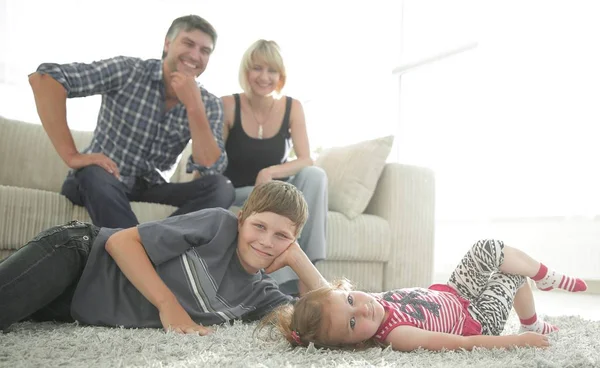 Portret van kinderen terwijl de ouders zitten op de Bank in levende roo — Stockfoto