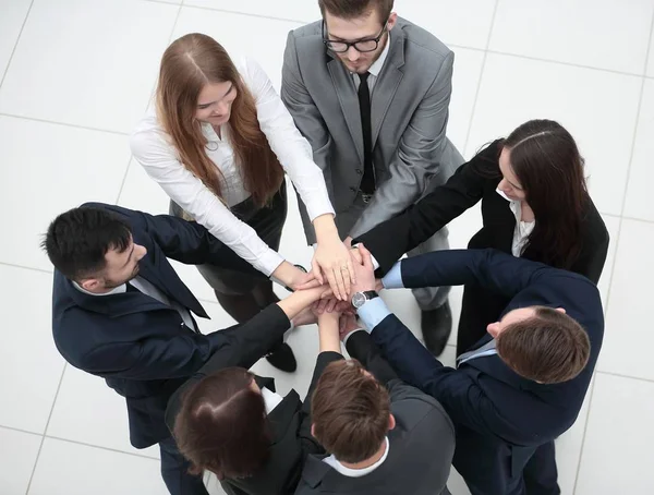 Крупный план. радостный бизнес-команда с сложенными руками вместе — стоковое фото