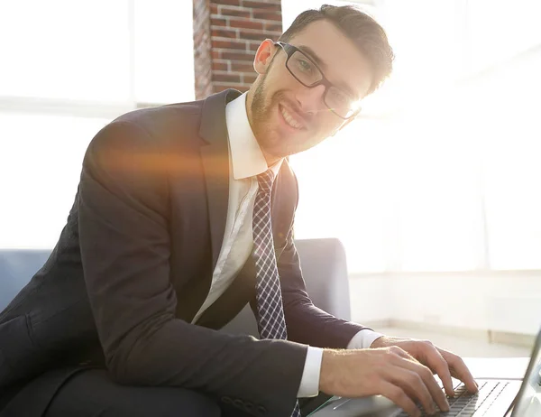 Jeune homme d'affaires utilisant un ordinateur portable et souriant — Photo