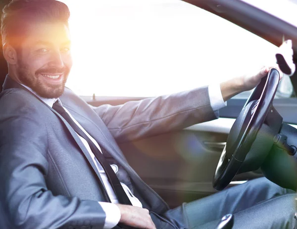 Hombre de negocios guapo en el asiento de los conductores en su coche — Foto de Stock