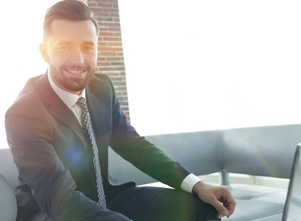 Hombre moderno que trabaja en el portátil en el vestíbulo de la oficina . — Foto de Stock