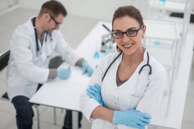 Laboratuarın arka planında kadın bilim adamı var.