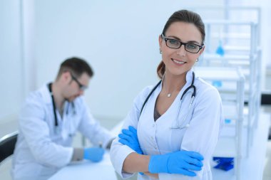 Laboratuarın arka planında kadın bilim adamı var.
