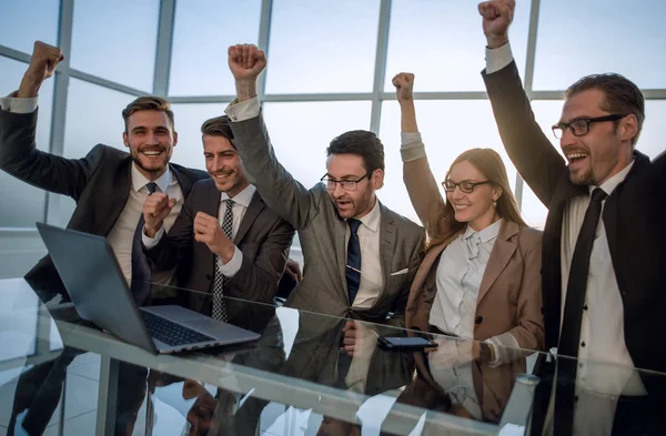 Hombres de negocios con los brazos levantados delante de la computadora portátil —  Fotos de Stock