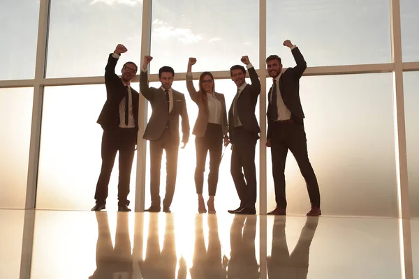 Business group holding hands up near the window — Stock Photo, Image