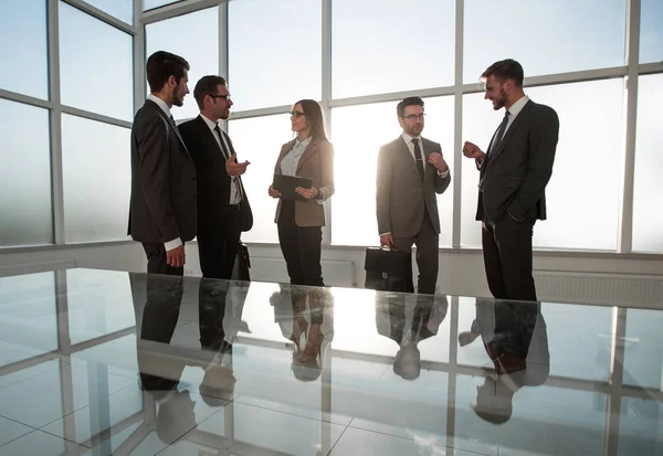 Empresários perto de uma janela em uma sala de reunião — Fotografia de Stock