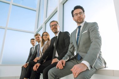 Bir pencere üzerinde oturan beş iş adamları sohbet