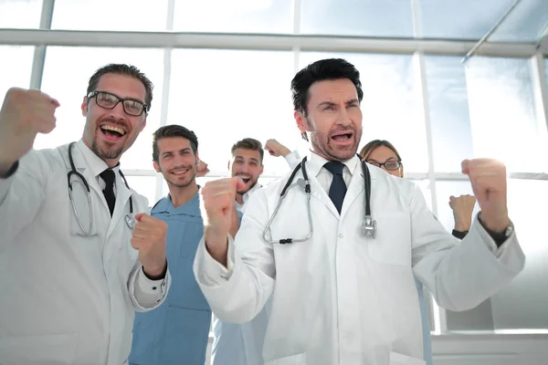 A victory sign of a team of doctors in white coats — Stock Photo, Image