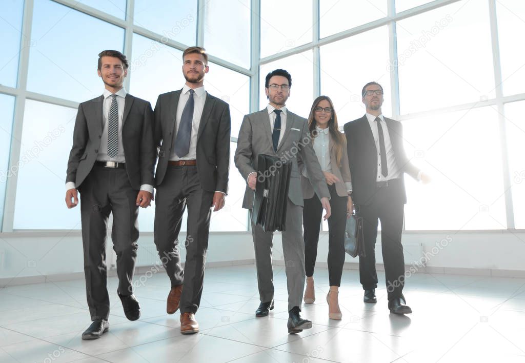 business people go down the hallway of a modern office