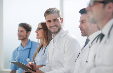 Gülümseyen bir doktorun ekibiyle oturmasına yakın durun.