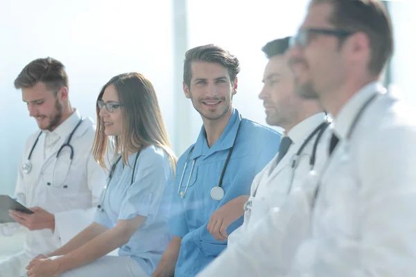 Крупним планом усміхнений лікар сидить зі своєю командою — стокове фото