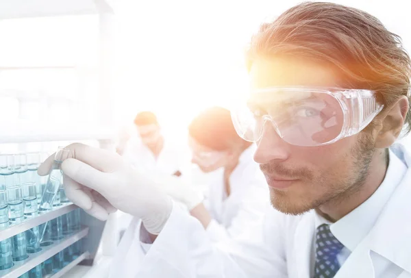 Ο άνθρωπος στα γυαλιά για να ελέγξετε το ρευστό in vitro. — Φωτογραφία Αρχείου