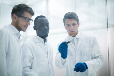 genç bilim adamı bir parmak cam kurulu gösterir.