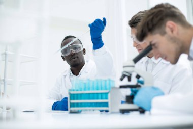 Dikiz aynası. Laboratuvar masasında bir grup bilim adamı.