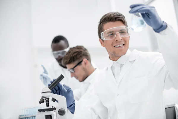 Group of young scientists conduct laboratory studies — Stock Photo, Image