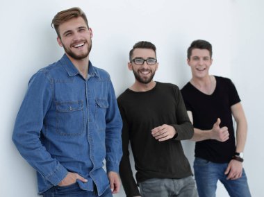 üç kişi duvara yaslanmış gülümseyen