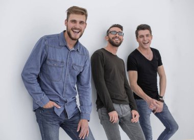 üç kişi duvara yaslanmış gülümseyen