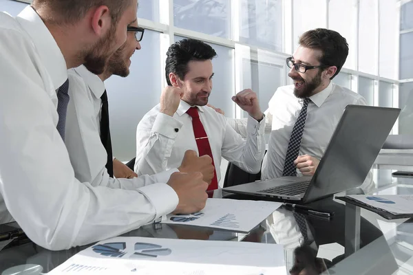 Equipe de negócios feliz sentado na mesa — Fotografia de Stock