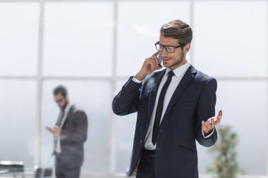 Kendine güvenen iş adamı cep telefonuyla konuşuyor..