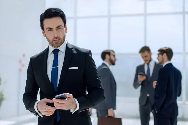 Affärsman med en smartphone på bakgrunden office — Stockfoto