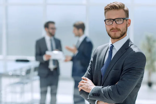 Selbstbewusster Geschäftsmann vor dem Hintergrund eines modernen Büros — Stockfoto