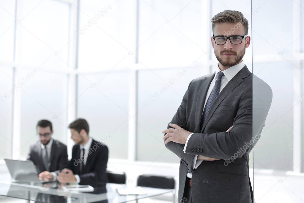 smiling businessman on blurred office background