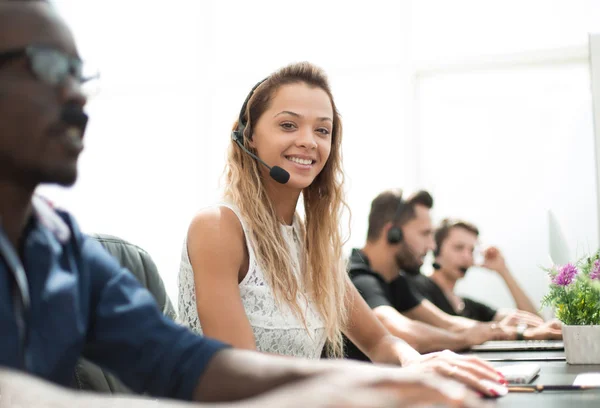 Souriant employé du centre d'appels assis à son bureau — Photo