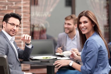 bir kafede bir masada oturan up.business takımı Kapat