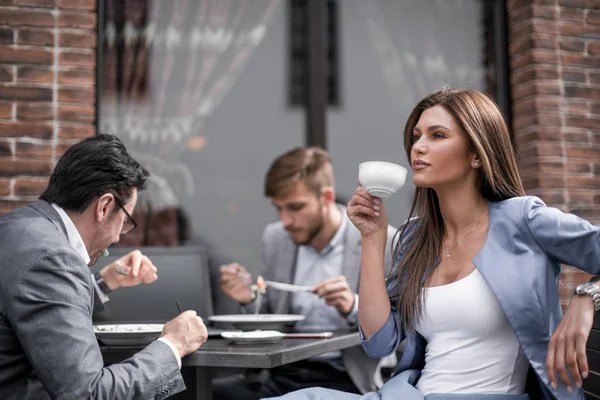 Mulher de negócios com uma xícara de café, sentado a uma mesa em um café acolhedor — Fotografia de Stock