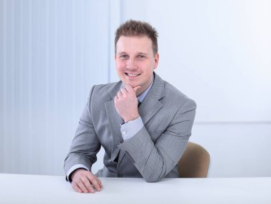 bir masanın arkasında oturan başarılı iş adamı