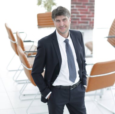 Bir boş toplantı odasında duran iş adamı