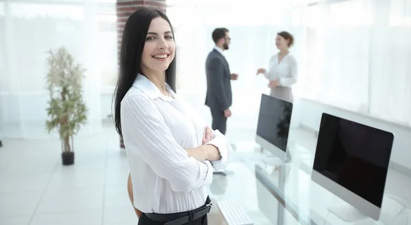 Im Vordergrund Geschäftsfrau, die neben einem Arbeitstisch steht — Stockfoto