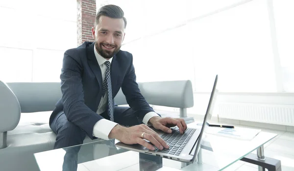 Homme qui travaille avec succès sur un ordinateur portable dans un bureau moderne — Photo