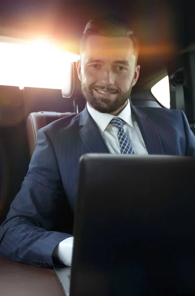 Uomo di successo seduto sul sedile posteriore di una macchina — Foto Stock