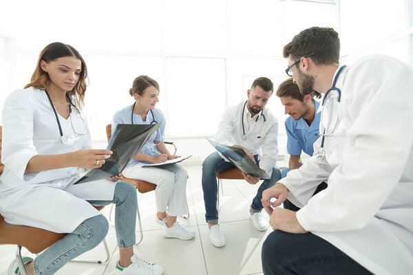 radiologists and a surgeon discussing a radiograph of a patient