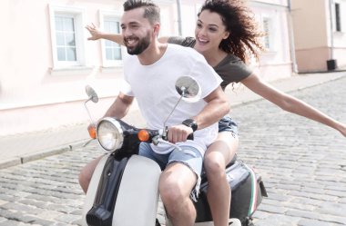 mutlu genç bir çift bir scooter üzerinde eğleniyor